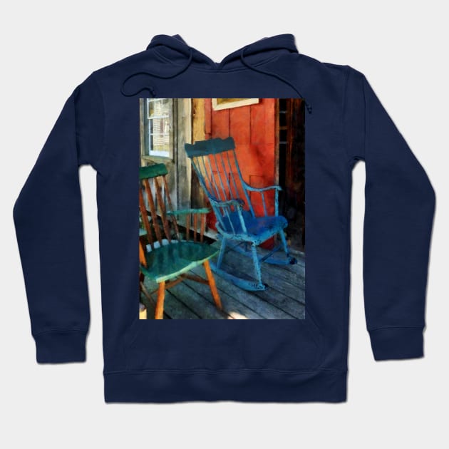 Blue and Green Rocking Chairs Against Red Door Hoodie by SusanSavad